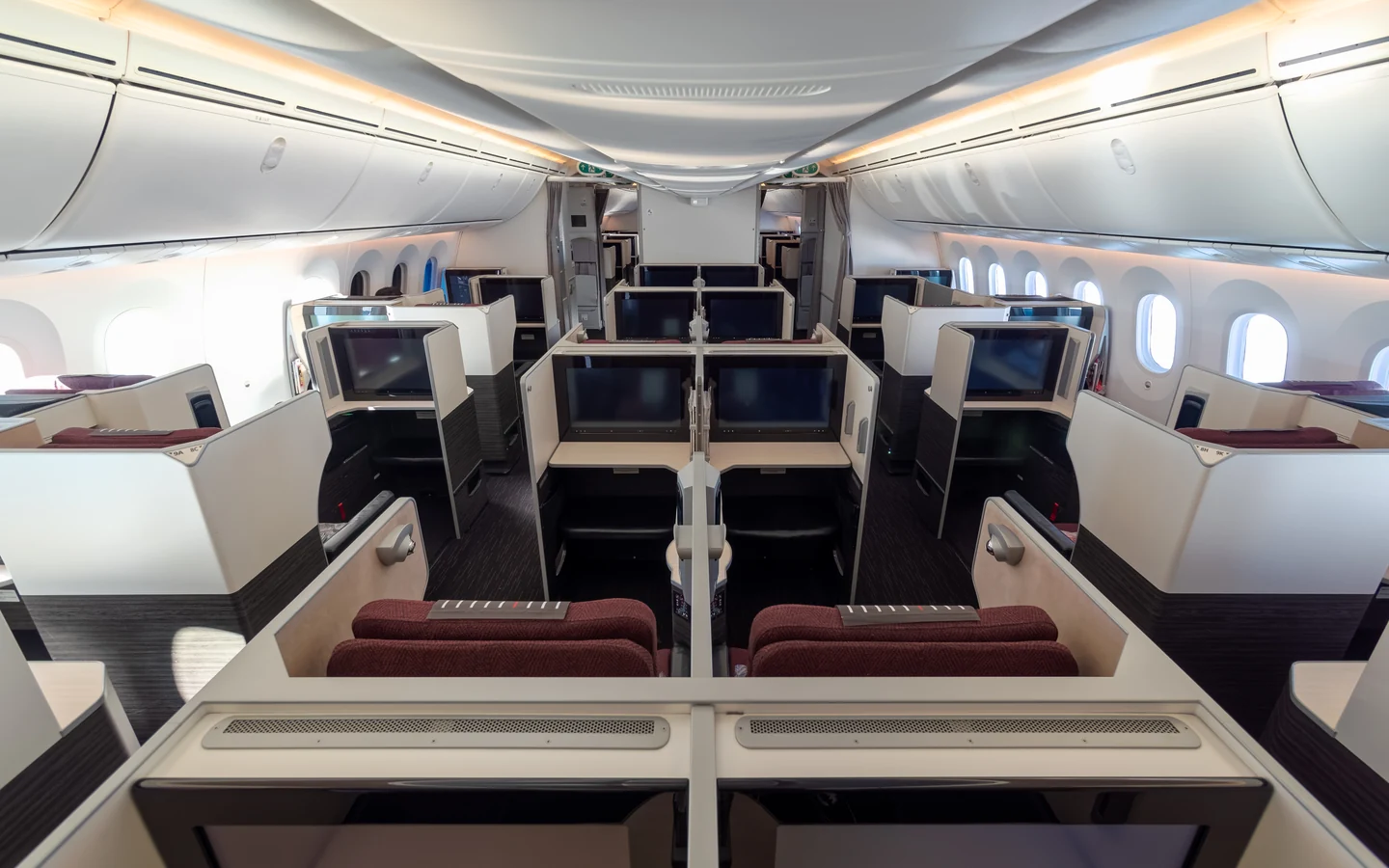 Japan Airlines Boeing 787-8 SKY SUITE business class cabin with burgundy seats and private partitions